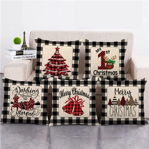 Set di cinque fodere per cuscini natalizi in lino con motivi festivi su un divano beige