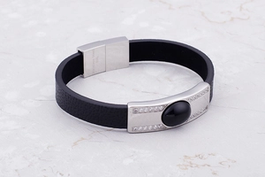 Macro shot of 316L stainless steel clasp and braided black leather on men's bracelet