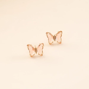 Detailed close-up of butterfly earrings with peach zircon stones and gold plating