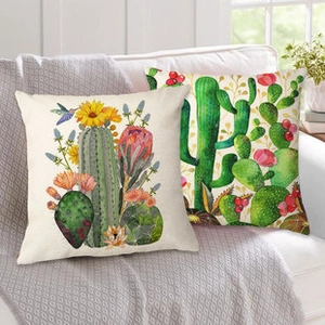 Detail of linen pillowcases with watercolor sunflower and hummingbird print on sofa