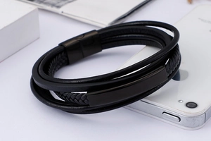 Detail of multi-layer black braided leather bracelet with stainless steel magnetic clasp