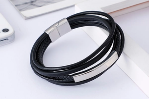 Detail of multi-layer black leather woven bracelet with silver magnetic steel clasp