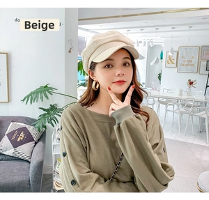 Beige cotton octagonal newsboy hat styled with olive green sweatshirt and gold earrings