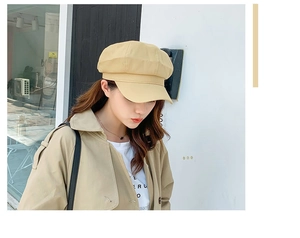 Close-up of a khaki cotton linen newsboy cap worn by a model in a minimalist style