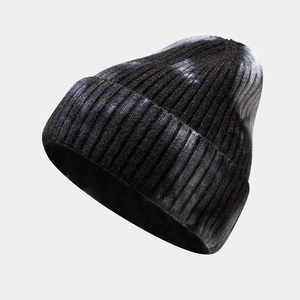 Close-up of tie-dye knit beanie showing rib-knit texture and soft black and grey yarn