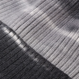 Macro shot of grey tie-dye ribbed knit fabric texture and soft wool stitching details