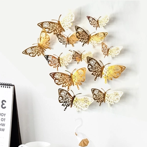 3D hollow butterfly wall stickers in gold and silver set on a minimalist white wall