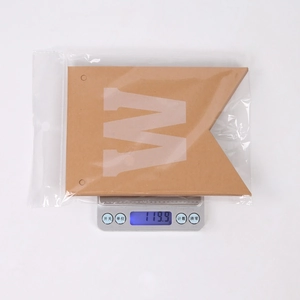 Close-up of a rustic brown kraft paper welcome banner being weighed at 119.9 grams