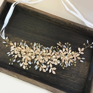 Macro detail of handmade bridal golden leaf vine headpiece with white beads and silk ribbon
