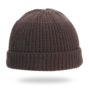 Detailed close-up of dark brown knit beanie showing ribbed texture and folded cuff design