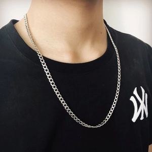 Close-up of 4mm silver stainless steel Cuban link chain worn by male model on black shirt