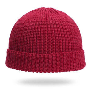 Close-up of wine red ribbed knit beanie showing thick texture and folded cuff detail