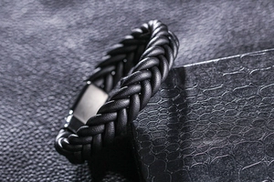 Vue macro du bracelet en cuir tressé noir pour homme avec fermoir magnétique sur une boîte