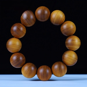 Macro detail of 20mm aged Thuja Sutchuenensis wood beads with fine oil texture