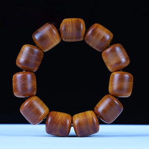 Macro detail of aged Thuja sutchuenensis wood beads with rich oil grain and texture