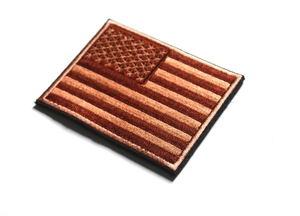 Close-up of brown and black USA flag embroidered tactical patch with velcro backing