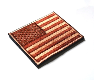 Close-up of rectangular USA flag tactical patch in tan and brown embroidery with hook backing