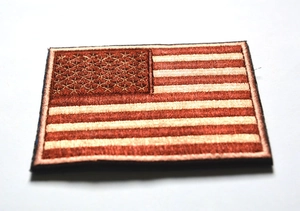 Close-up of embroidered USA flag tactical patch with desert sand color stitching