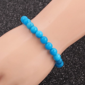 Ethnic style blue turquoise beaded bracelet for men on a display hand with black background