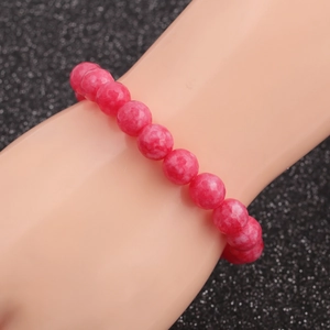 Close-up of natural pink tiger eye stone beaded bracelet with polished round texture