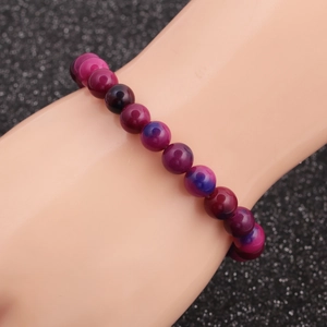 Detailed shot of tiger eye beaded bracelet with purple and blue gradient on hand model