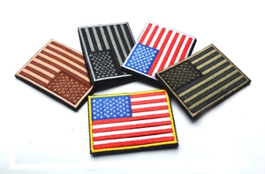 Detail of five embroidered USA flag patches in various tactical color schemes