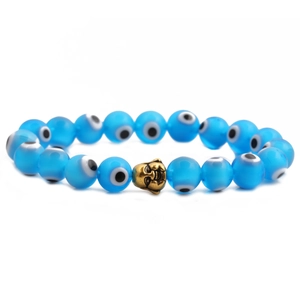Close-up of blue Evil Eye beads with a gold Buddha head charm on a beaded bracelet