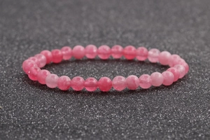 Detalle de la pulsera de cuentas de ágata rosa de 6mm sobre fondo negro brillante con 24 cuentas