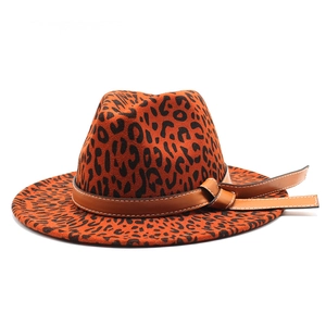 Detail of leopard print fedora hat featuring a brown leather decorative band and wide brim