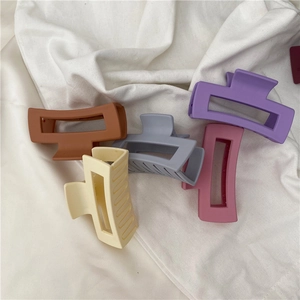 Minimalist matte geometric hair claws in five Morandi colors on white fabric background