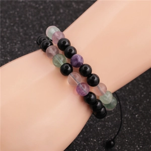 Stackable beaded bracelet set with black and multicolor stone beads on model's wrist