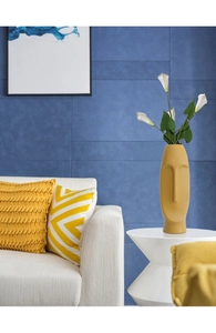 Detail of creative matte mustard yellow face ceramic vase in a modern interior setting