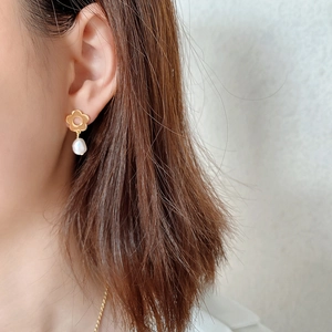 Detail of 925 silver golden flower earrings with hanging pearls on female model
