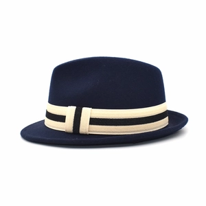 Detail of navy wool fedora hat featuring a white ribbed ribbon with black stripe accents