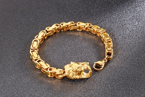 Detailed close-up of a men's golden lion head bracelet with a thick cuban link chain