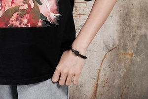 Close-up of a men's black metal lion head bracelet with intricate punk style carvings