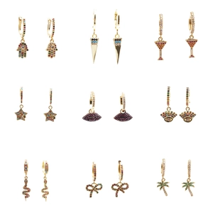 Set of 9 gold earrings with colorful zircon in various shapes on a white background