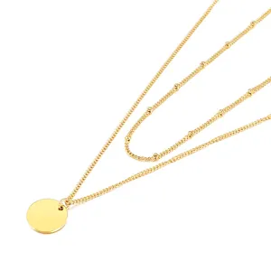 Layered gold snake chain necklace with round disk pendant and minimalist beaded satellite chain