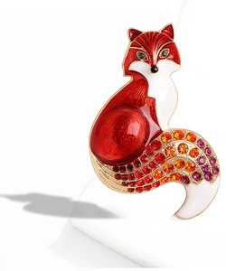 Detailed close-up of a fox brooch featuring red enamel work and colorful rhinestones
