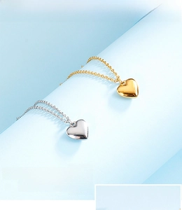 Macro detail of polished heart pendants in gold and silver finish with cross chains