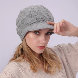 Detalle de gorro de punto trenzado gris con forro polar grueso y visera para el invierno