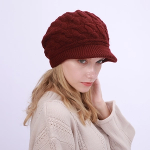 Primer plano de gorro de punto trenzado color burdeos con visera para invierno cálido