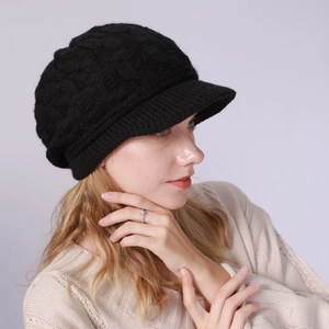 Detalle de gorra de punto negro grueso con patrón trenzado y forro térmico cálido