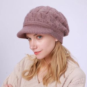 Textura de punto detallada de un gorro de invierno rosa palo con forro cálido y visera suave