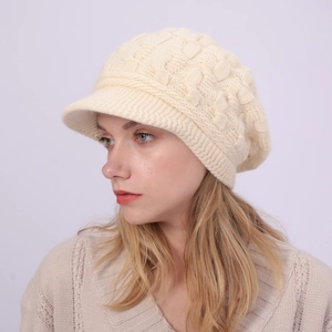 Primer plano de la textura de punto trenzado crema y visera en un gorro de invierno