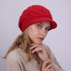 Detalle de gorra de punto rojo con trenzas y visera para mujer en estilo invernal