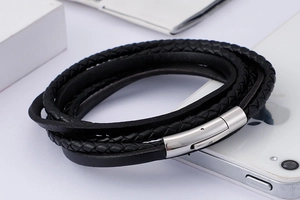 Detail shot of multi-layer black braided leather bracelet with silver metal magnetic clasp