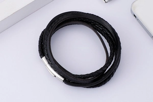 Detail of multi-layer black braided leather bracelet with silver magnetic metal clasp