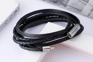 Macro view of multi-layer black leather bracelet with braided texture and metal clasp