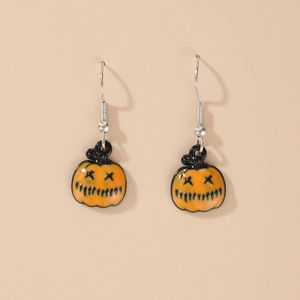 Quirky Halloween orange pumpkin drop earrings with black evil face on skin tone background